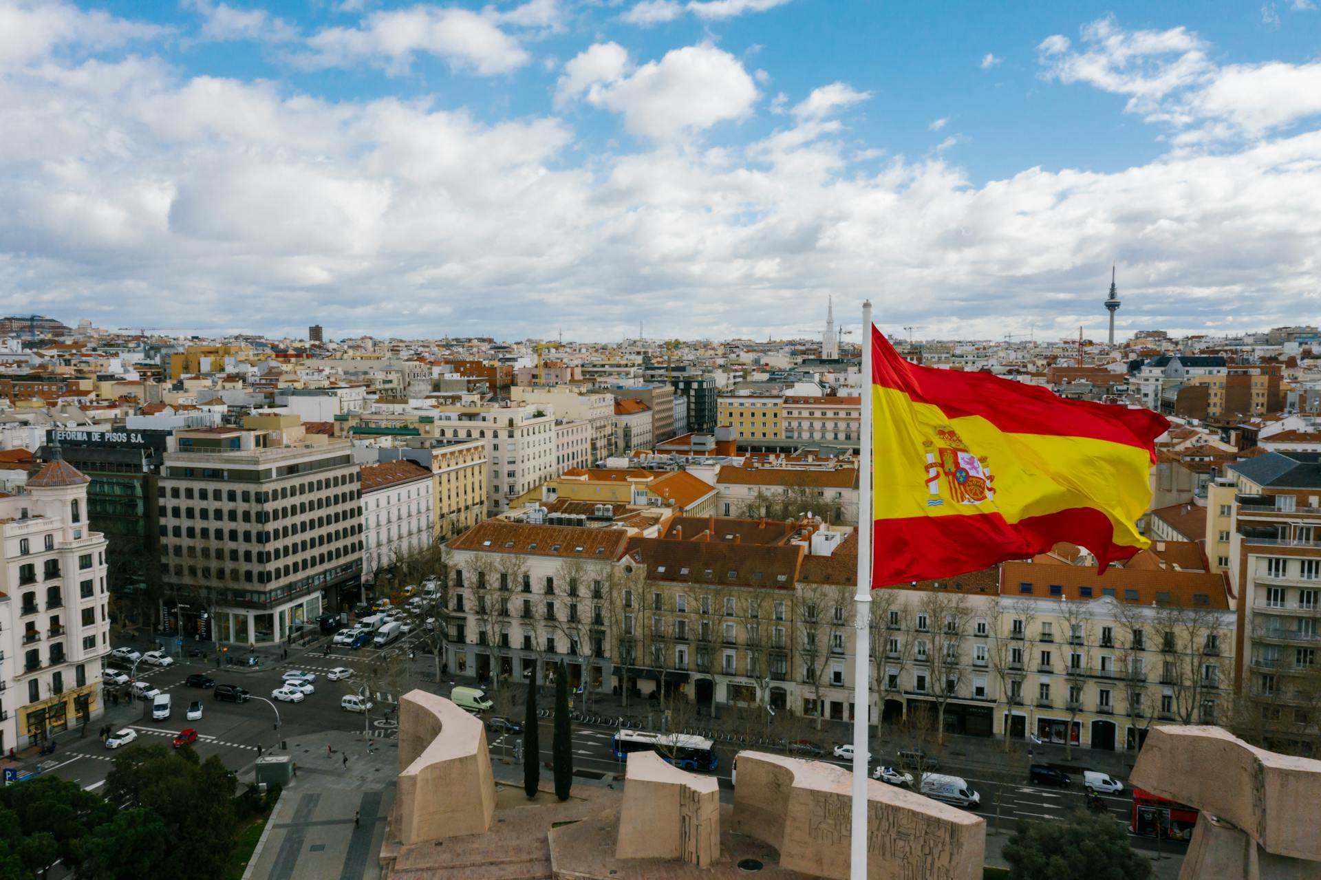 Spanish national flag against cityscape.